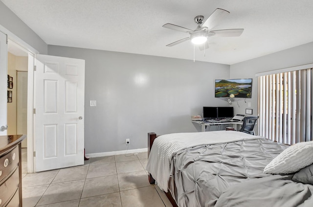 tiled bedroom with ceiling fan and a textured ceiling