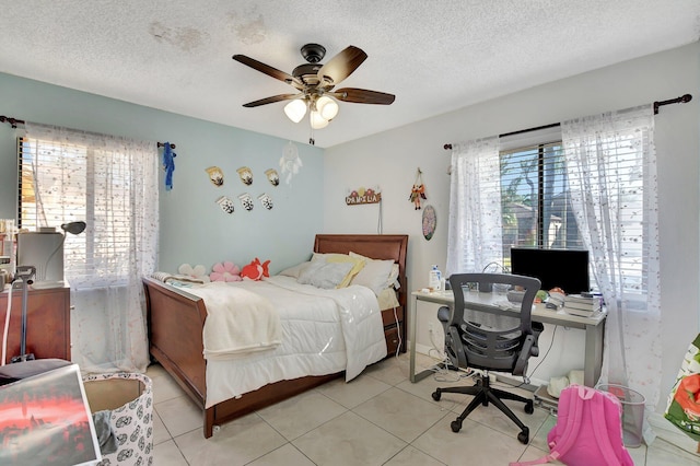 tiled bedroom with a textured ceiling and ceiling fan