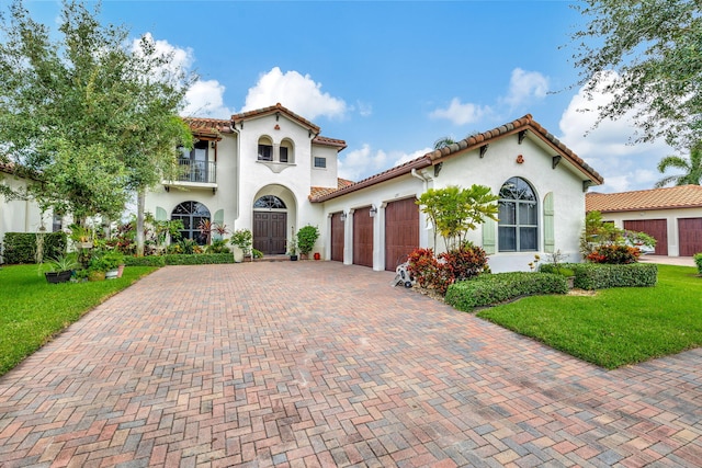 mediterranean / spanish house with a balcony, a front lawn, and a garage