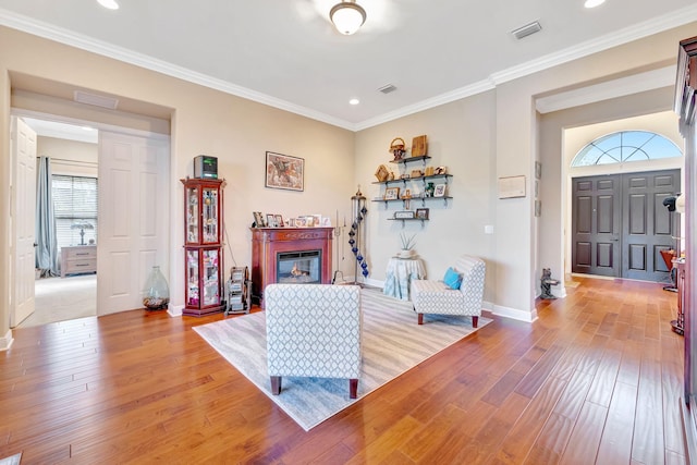 living room with light hardwood / wood-style floors and ornamental molding