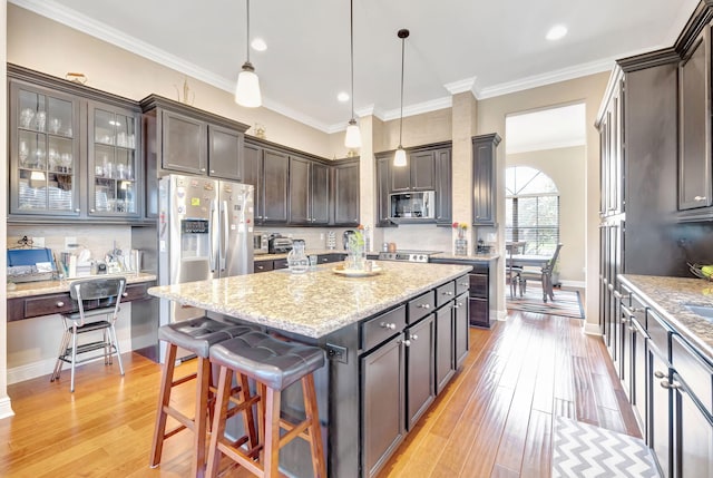 kitchen featuring dark brown cabinetry, light hardwood / wood-style floors, and a kitchen island