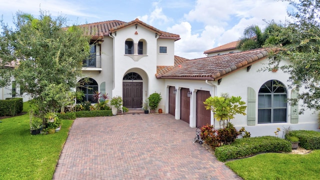 mediterranean / spanish-style home featuring a balcony, a front yard, and a garage