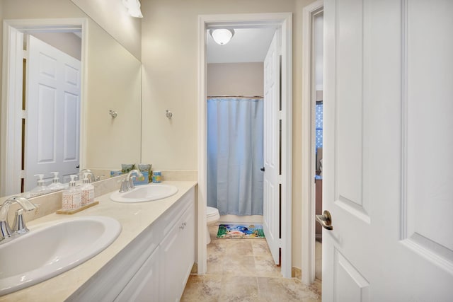 bathroom with vanity, curtained shower, and toilet