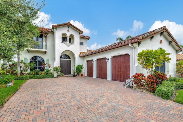 mediterranean / spanish-style home with a balcony and a garage