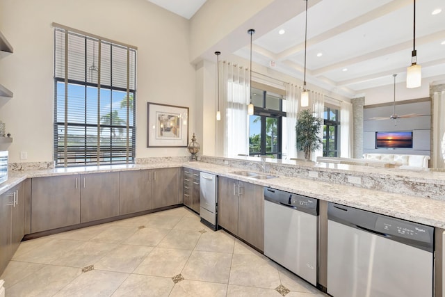 kitchen featuring dishwasher, ceiling fan, light stone countertops, and sink