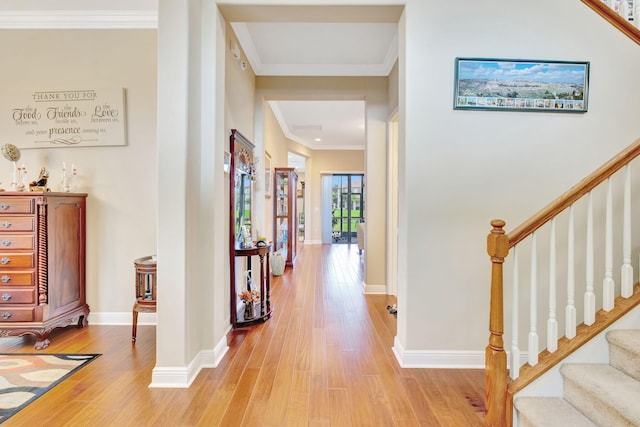 hallway with crown molding and light hardwood / wood-style floors