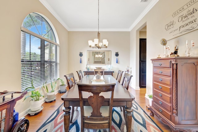 dining space with a chandelier, light hardwood / wood-style floors, and ornamental molding