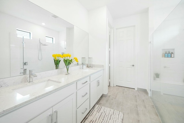 bathroom featuring vanity, wood-type flooring, and walk in shower