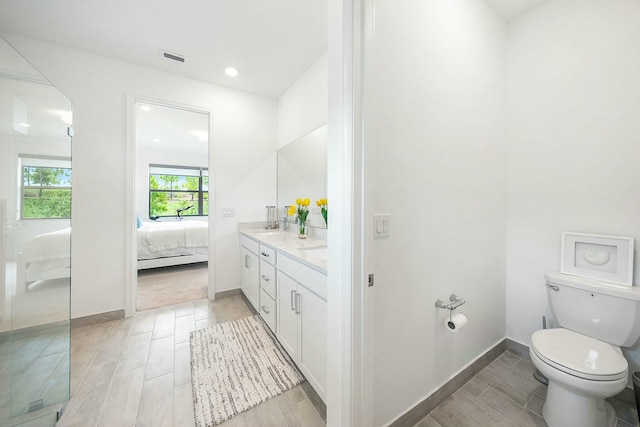 bathroom featuring wood-type flooring, vanity, and toilet