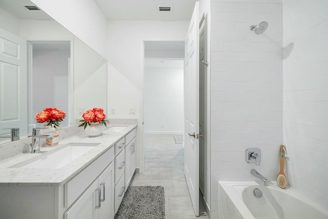 bathroom with vanity, wood-type flooring, and tiled shower / bath