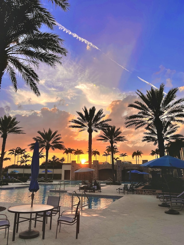 pool at dusk featuring a water view