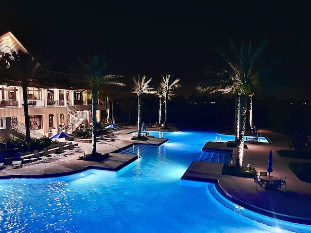 pool at twilight with a patio area