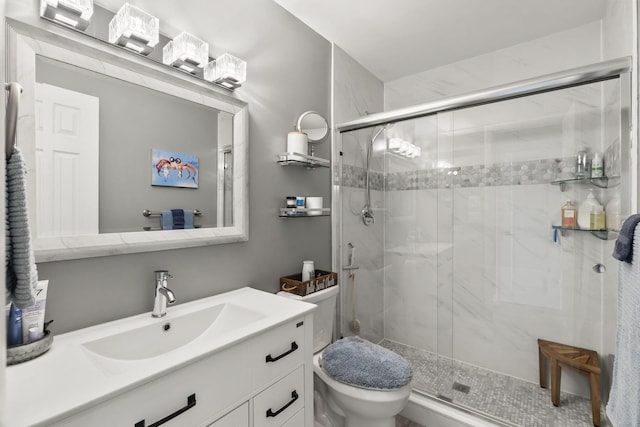 bathroom featuring vanity, a shower with shower door, and toilet