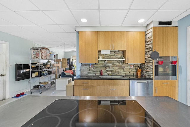 kitchen with a paneled ceiling, stainless steel appliances, tasteful backsplash, and sink