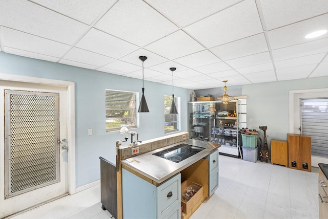 kitchen with decorative light fixtures, a drop ceiling, and black electric cooktop