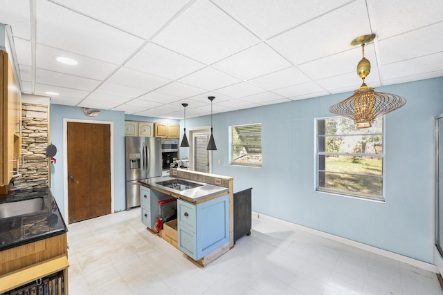 kitchen with a paneled ceiling, sink, hanging light fixtures, and appliances with stainless steel finishes