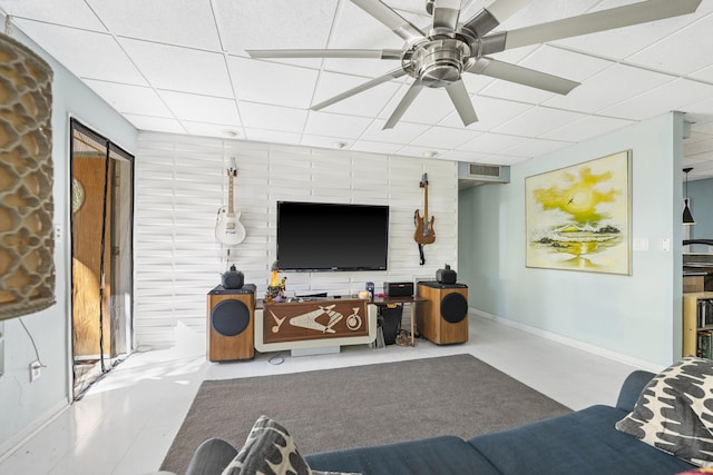 living room featuring a drop ceiling and ceiling fan