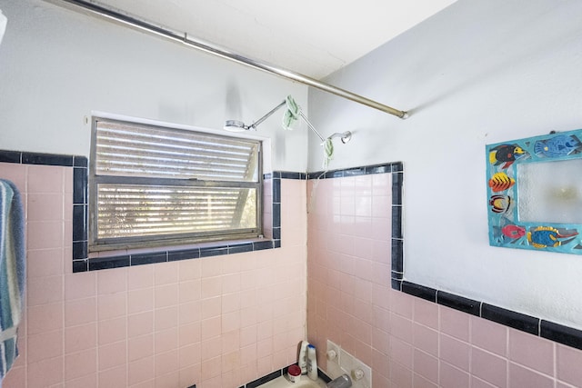 bathroom featuring tile walls and tiled shower / bath