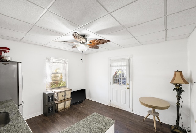 interior space featuring dark hardwood / wood-style flooring, ceiling fan, and a paneled ceiling