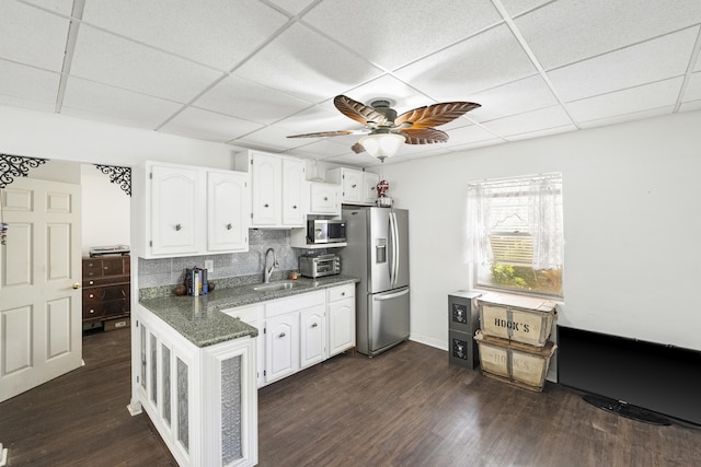 kitchen with backsplash, stainless steel appliances, ceiling fan, dark wood-type flooring, and white cabinets