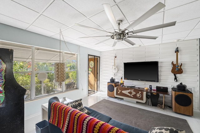 living room featuring a drop ceiling and ceiling fan