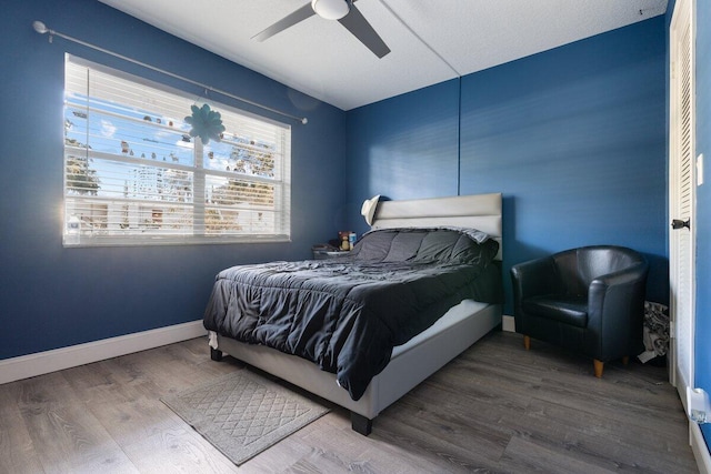 bedroom with ceiling fan and wood-type flooring