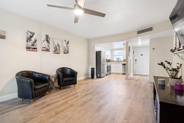 1638 Embassy Dr Unit 103, West Palm Beach, FL 33401 - living area with light wood-type flooring, baseboards, visible vents, and ceiling fan