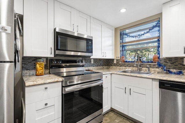 kitchen featuring tasteful backsplash, sink, white cabinets, and stainless steel appliances