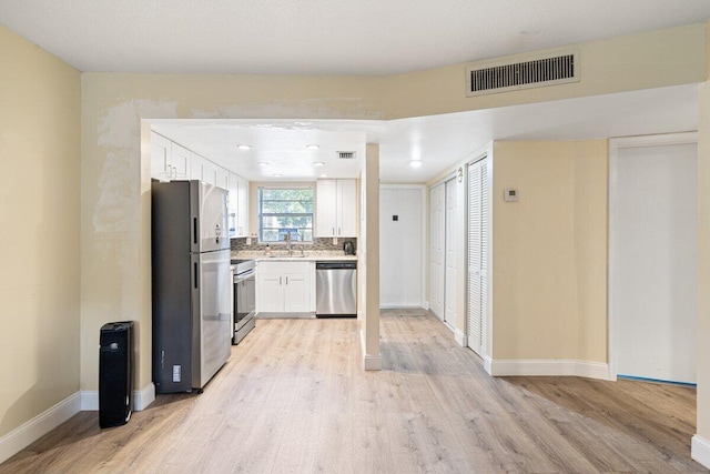 1638 Embassy Dr Unit 103, West Palm Beach, FL 33401 - kitchen with stainless steel appliances, light wood-style flooring, a sink, visible vents, and light countertops