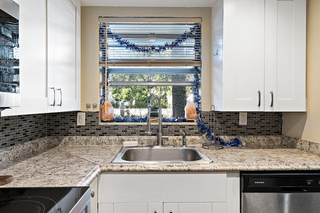 kitchen with backsplash, sink, white cabinets, and stainless steel dishwasher