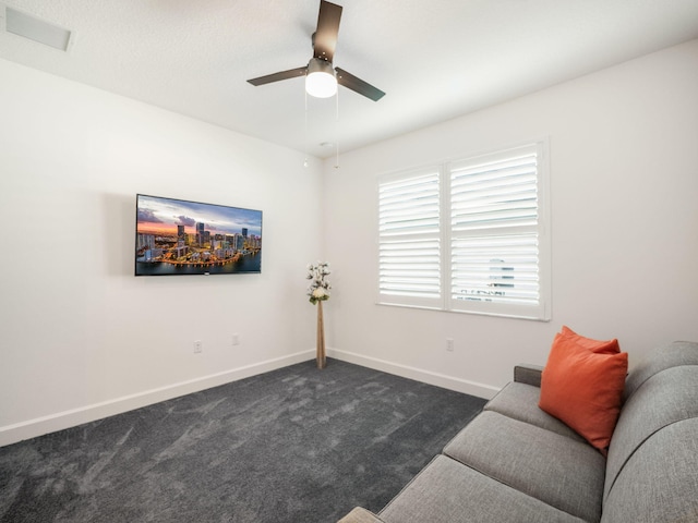 sitting room featuring dark carpet and ceiling fan