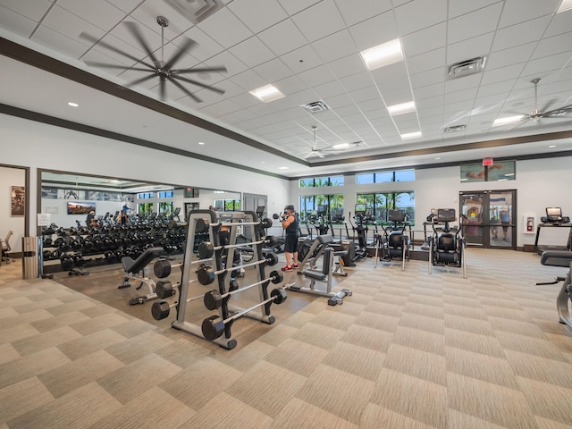 exercise room featuring light carpet, a drop ceiling, and ceiling fan