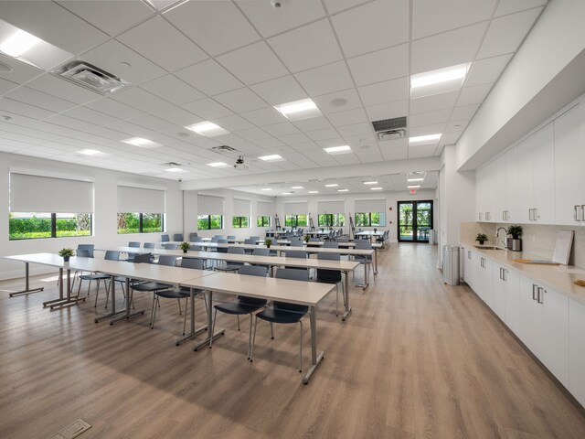 dining room featuring a drop ceiling, light hardwood / wood-style floors, and sink