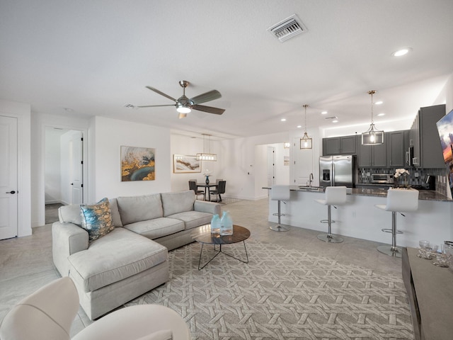 living room featuring ceiling fan and sink