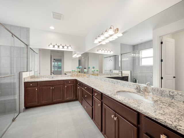 bathroom with tile patterned flooring, vanity, and a shower with door