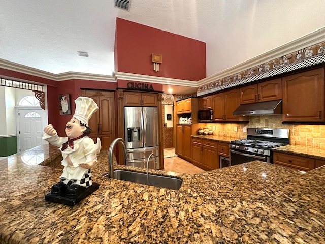 kitchen featuring decorative backsplash, stainless steel appliances, crown molding, sink, and a high ceiling