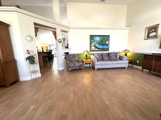 living room featuring a towering ceiling and light hardwood / wood-style floors