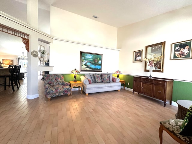 living room with light hardwood / wood-style flooring and a towering ceiling