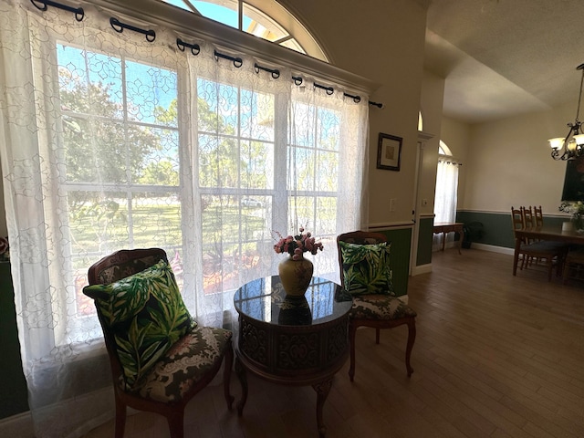 dining area featuring hardwood / wood-style floors, an inviting chandelier, vaulted ceiling, and plenty of natural light