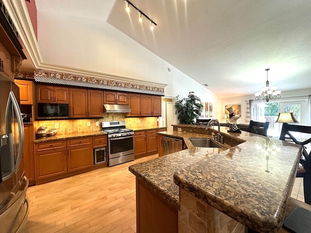 kitchen featuring a textured ceiling, stainless steel appliances, and a spacious island