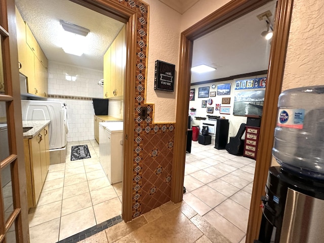 17976 88th Rd N, Loxahatchee, FL 33470 - hallway with separate washer and dryer, light tile patterned floors, a textured wall, tile walls, and a textured ceiling