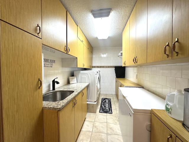 17976 88th Rd N, Loxahatchee, FL 33470 - laundry area featuring washing machine and clothes dryer, cabinet space, light tile patterned floors, a textured ceiling, and tile walls