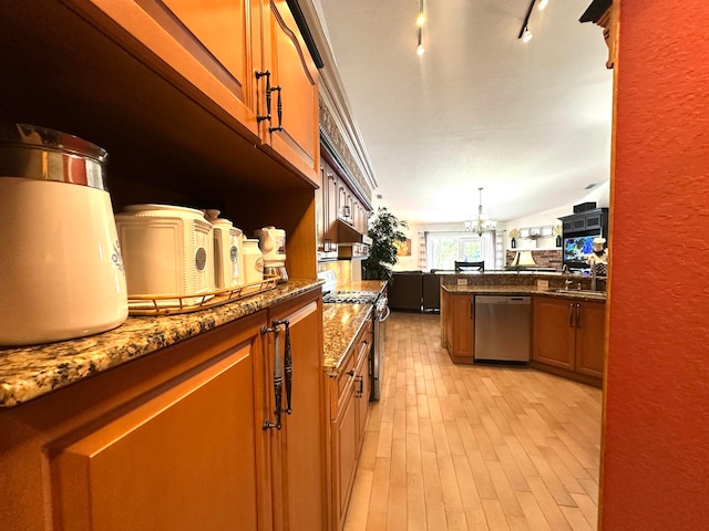 kitchen with light hardwood / wood-style flooring, a notable chandelier, dark stone counters, vaulted ceiling, and appliances with stainless steel finishes