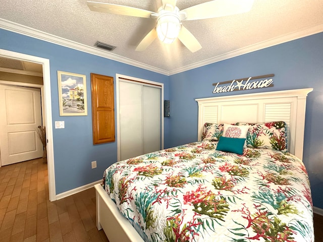 bedroom featuring a textured ceiling, dark wood-type flooring, ceiling fan, and crown molding