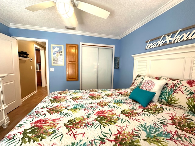 bedroom featuring crown molding, ceiling fan, a textured ceiling, dark hardwood / wood-style flooring, and a closet