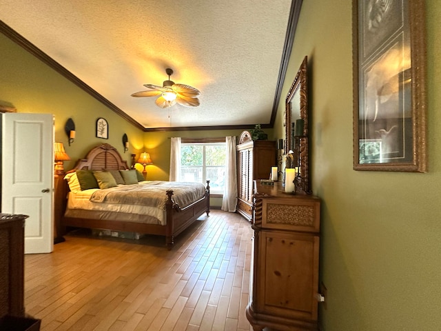 bedroom featuring ceiling fan, crown molding, wood-type flooring, and a textured ceiling