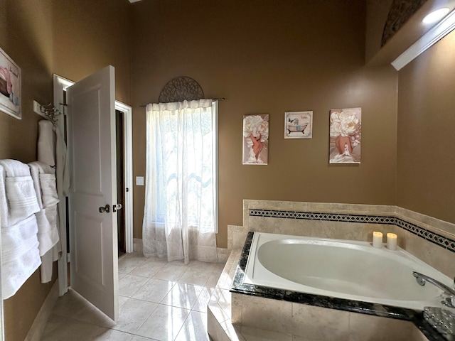 bathroom with a relaxing tiled tub and tile patterned floors