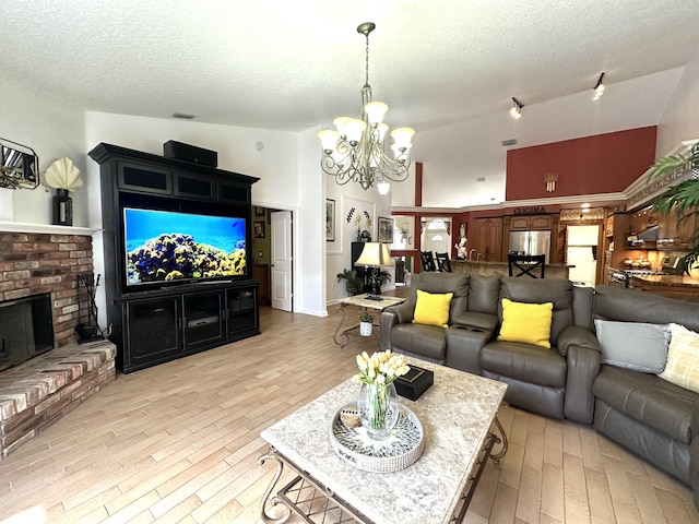 17976 88th Rd N, Loxahatchee, FL 33470 - living area featuring a chandelier, a textured ceiling, light wood-type flooring, a towering ceiling, and a brick fireplace