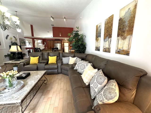 17976 88th Rd N, Loxahatchee, FL 33470 - living room with light wood-style floors, a chandelier, a towering ceiling, and a textured ceiling