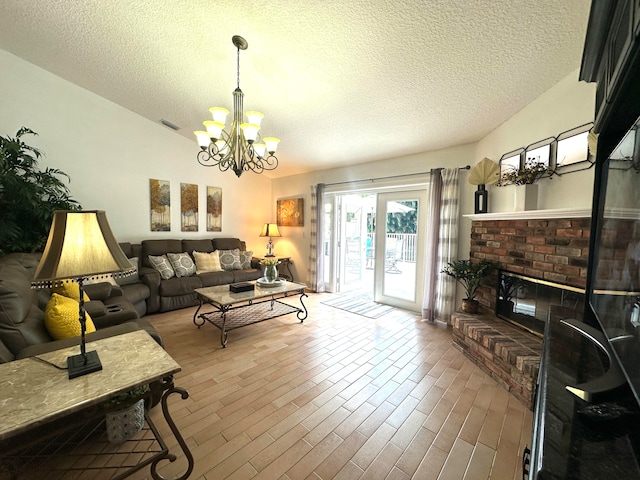 living room with a notable chandelier, a fireplace, and a textured ceiling